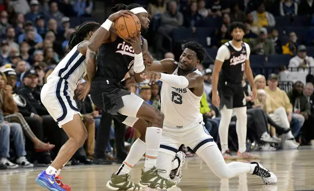 Portland Trail Blazers forward Jerami Grant (9) handles the ball against Memphis Grizzlies forward Jaren Jackson Jr. (13) in the first half of an NBA basketball game Monday, Nov. 25, 2024, in Memphis, Tenn. (AP Photo/Brandon Dill)