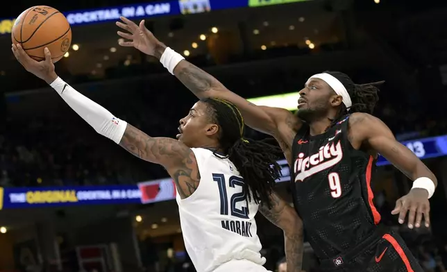 Memphis Grizzlies guard Ja Morant (12) shows ahead of Portland Trail Blazers forward Jerami Grant (9) in the first half of an NBA basketball game Monday, Nov. 25, 2024, in Memphis, Tenn. (AP Photo/Brandon Dill)