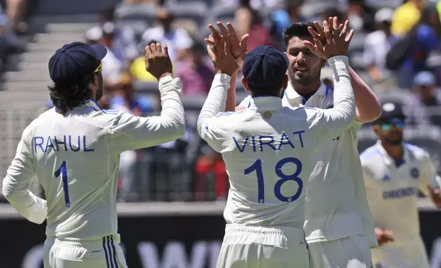 India's Harshit Rana, right, facing the camera, celebrates with teammate Virat Kohli the wicket of Australia's Nathan Lyon on the second day of the first cricket test between Australia and India in Perth, Australia, Saturday, Nov. 23, 2024. (AP Photo/Trevor Collens)