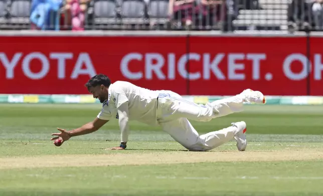 India's Nitish Kumar Reddy fields the ball as he loses his balance after bowling a delivery on the second day of the first cricket test between Australia and India in Perth, Australia, Saturday, Nov. 23, 2024. (AP Photo/Trevor Collens)