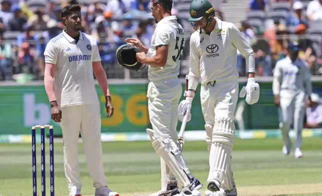 India's Harshit Rana, left, speaks to Australia's Mitchell Starc after the latter was hit on his helmet by a ball from him on the second day of the first cricket test between Australia and India in Perth, Australia, Saturday, Nov. 23, 2024. (AP Photo/Trevor Collens)