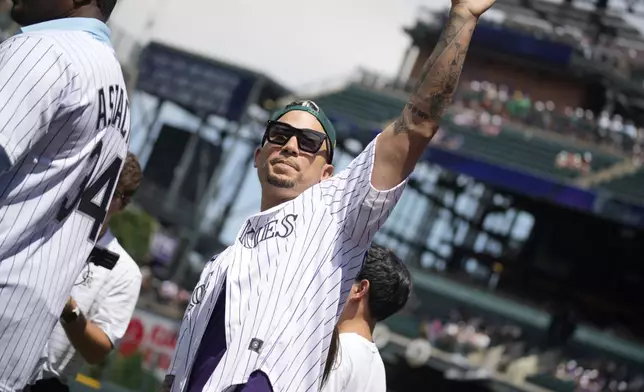 FILE - Retired Colorado Rockies outfielder Carlos Gonzalez waves to the crowd during a promotion to mark the team's 30th anniversary before the Rockies host the Oakland Athletics in a baseball game, July 30, 2023, in Denver. (AP Photo/David Zalubowski, file)