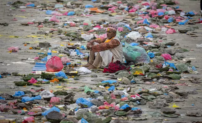 FILE- A priest sits amid the garbage left by devotees during 'Kuse Aunsi' at Gokarneshwor Temple in Kathmandu, Nepal, Monday, Sept. 2, 2024. (AP Photo/Niranjan Shrestha)