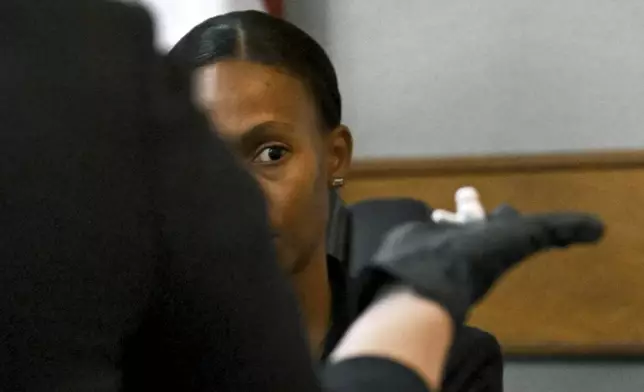 Prosecutor Sheila Ross holds an AirPod earpiece Laken Riley worn as GBI Crime Scene Specialist Daniella Stuart testifies on the witness stand during the trial of Jose Ibarra, accused of killing a Georgia nursing student earlier this year, at Athens-Clarke County Superior Court, Friday, Nov. 15, 2024, in Athens, Ga. (Hyosub Shin/Atlanta Journal-Constitution via AP, Pool)