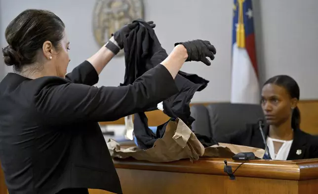 Prosecutor Sheila Ross holds clothings Laken Riley worn as GBI Crime Scene Specialist Daniella Stuart, right, testifies on the witness stand during the trial of Jose Ibarra, accused of killing a Georgia nursing student earlier this year, at Athens-Clarke County Superior Court, Friday, Nov. 15, 2024, in Athens. (Hyosub Shin/Atlanta Journal-Constitution via AP, Pool)