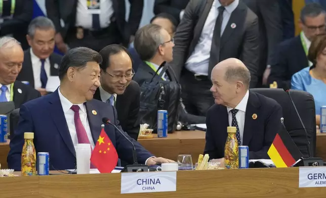 China's President Xi Jinping, left, talks with Germany's Chancellor Olaf Scholz during the G20 Summit leaders meeting in Rio de Janeiro, Monday, Nov. 18, 2024. (AP Photo/Eraldo Peres)