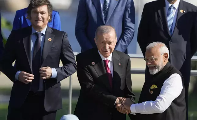 Argentina's President Javier Milei, left, Turkey's President Recep Tayyip Erdogan, center, and India's Prime Minister Narendra Modi prepare for a group photo at the G20 Summit in Rio de Janeiro, Monday, Nov. 18, 2024. (AP Photo/Eraldo Peres)