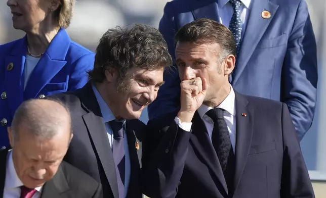 Argentina's President Javier Milei, left, and France's President Emmanuel Macron talk during a group photo at the G20 Summit in Rio de Janeiro, Monday, Nov. 18, 2024. (AP Photo/Eraldo Peres)