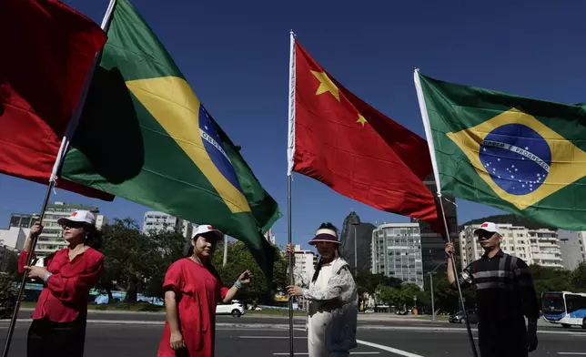 People hold Brazilian and Chinese flags during the G20 Summit in Rio de Janeiro, Monday, Nov. 18, 2024. (AP Photo/Bruna Prado)