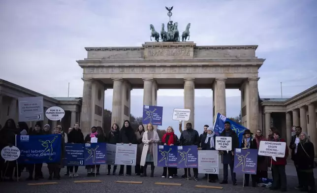 Women attend a protest of the Terre des Femmes human rights organisation together with German Minister for Family Affairs, Senior Citizens, Women and Youth, Lisa Paus, center, to mark the International Day for the Elimination of Violence Against Women in front of the Brandenburg Gate in Berlin, Germany, Monday, Nov. 25, 2024. (AP Photo/Markus Schreiber)