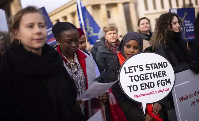 Women attend a protest of the Terre des Femmes human rights organisation to mark the International Day for the Elimination of Violence Against Women in front of the Brandenburg Gate in Berlin, Germany, Monday, Nov. 25, 2024. FGM stands Female genital mutilation. (AP Photo/Markus Schreiber)