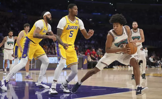 Memphis Grizzlies forward Jaylen Wells (0) dribbles next to Los Angeles Lakers forward Cam Reddish (5) during the first half of an NBA basketball game Wednesday, Nov. 13, 2024, in Los Angeles. (AP Photo/Marcio Jose Sanchez)