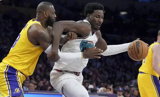 Memphis Grizzlies forward Jaren Jackson Jr., right, is defended by Los Angeles Lakers forward LeBron James during the first half of an NBA basketball game Wednesday, Nov. 13, 2024, in Los Angeles. (AP Photo/Marcio Jose Sanchez)