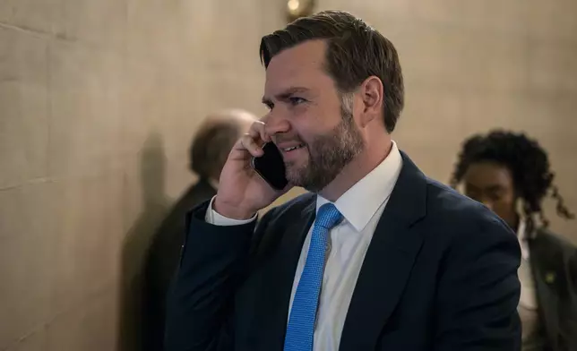 Vice President-elect JD Vance speaks on his mobile phone as he arrives for private meetings at the Capitol in Washington, Wednesday, Nov. 20, 2024. (AP Photo/Ben Curtis)