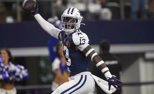 Dallas Cowboys linebacker DeMarvion Overshown (13) celebrates as he runs in for a touchdown on interception against the New York Giants during the first half of an NFL football game in Arlington, Texas, Thursday, Nov. 28, 2024. (AP Photo/Tony Gutierrez)