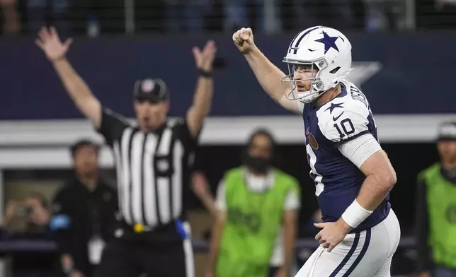 Dallas Cowboys quarterback Cooper Rush (10) celebrates after running back Rico Dowdle (23) ran for a touchdown against the New York Giants during the second half of an NFL football game in Arlington, Texas, Thursday, Nov. 28, 2024. (AP Photo/Tony Gutierrez)