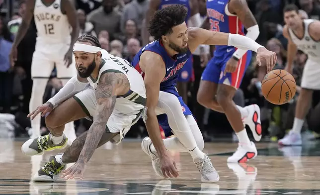 Milwaukee Bucks' Gary Trent Jr. and Detroit Pistons' Cade Cunningham go after a loose ball during the second half of an NBA basketball game Wednesday, Nov. 13, 2024, in Milwaukee. (AP Photo/Morry Gash)