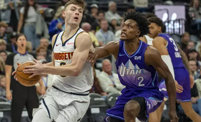 Denver Nuggets guard Christian Braun is guarded by, Utah Jazz guard Collin Sexton, during the first half of an NBA basketball game Wednesday, Nov. 27, 2024, in Salt Lake City. (AP Photo/Rick Egan)