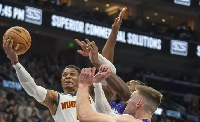 Denver Nuggets guard Russell Westbrook (4) takes the ball to the basket against Jazz guard Keyonte George and Jazz forward Drew Eubanks during the first half of an NBA basketball game Wednesday, Nov. 27, 2024, in Salt Lake City. (AP Photo/Rick Egan)