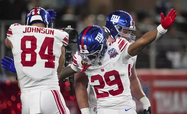 New York Giants running back Tyrone Tracy Jr. (29) celebrates his touchdown against the Dallas Cowboys with tight end Theo Johnson (84) during the first half of an NFL football game in Arlington, Texas, Thursday, Nov. 28, 2024. (AP Photo/Tony Gutierrez)