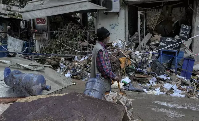 A man passes in front of a destroyed building hit on Monday evening by an Israeli airstrike in central Beirut, Lebanon, Tuesday, Nov. 19, 2024. (AP Photo/Bilal Hussein)