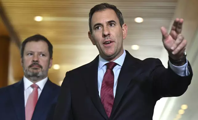 Australian Treasurer Jim Chalmers, right, gestures as he and Industry Minister Ed Husic speak to the media during a press conference at Parliament House in Canberra, Friday, Nov. 22, 2024. (Lukas Coch/AAP Image via AP)