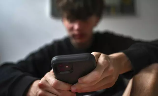 A teenager uses his mobile phone to access social media, Sydney, Wednesday, Nov. 13, 2024. (Dean Lewins/AAP Image VIA AP)