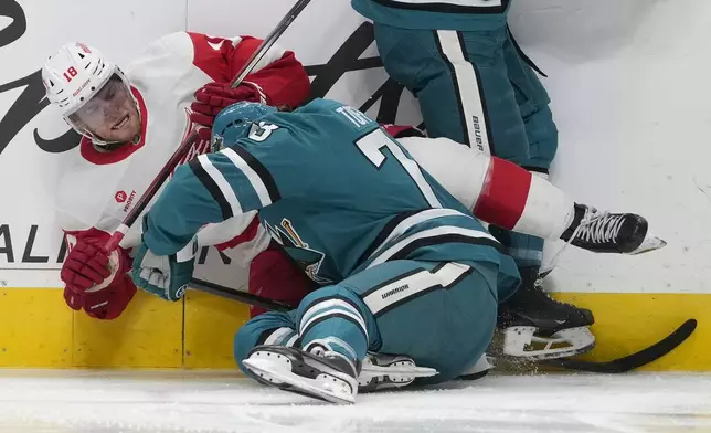 Detroit Red Wings center Andrew Copp, top, falls to the ice over San Jose Sharks center Tyler Toffoli during the second period of an NHL hockey game in San Jose, Calif., Monday, Nov. 18, 2024. (AP Photo/Jeff Chiu)