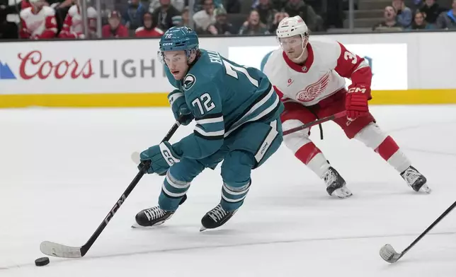 San Jose Sharks left wing William Eklund (72) skates toward the puck in front of Detroit Red Wings right wing Christian Fischer during the first period of an NHL hockey game in San Jose, Calif., Monday, Nov. 18, 2024. (AP Photo/Jeff Chiu)