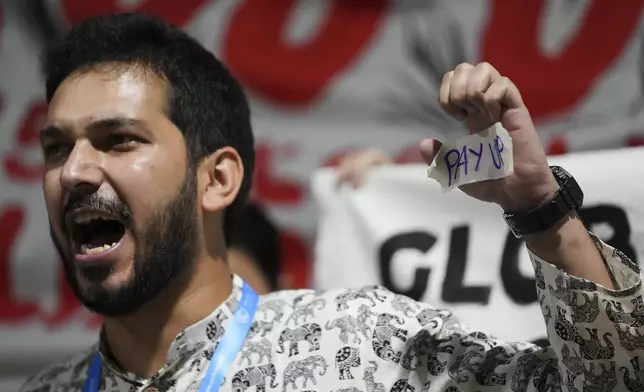 An activist displays "pay up" on his hand during a demonstration for climate finance at the COP29 U.N. Climate Summit, Friday, Nov. 22, 2024, in Baku, Azerbaijan. (AP Photo/Sergei Grits)