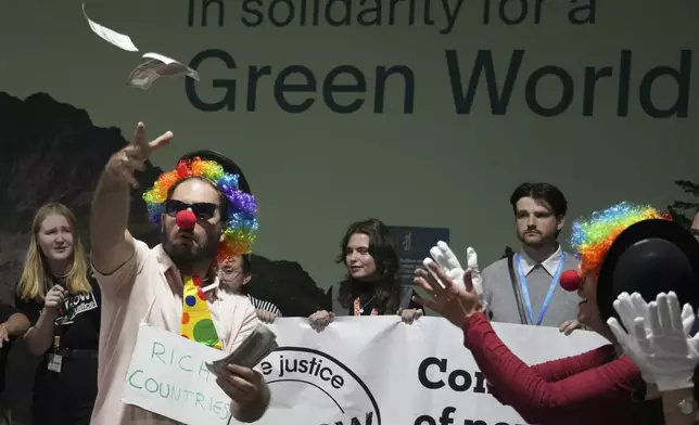 Activists dressed as clowns participate in a demonstration for climate finance at the COP29 U.N. Climate Summit, Friday, Nov. 22, 2024, in Baku, Azerbaijan. (AP Photo/Sergei Grits)