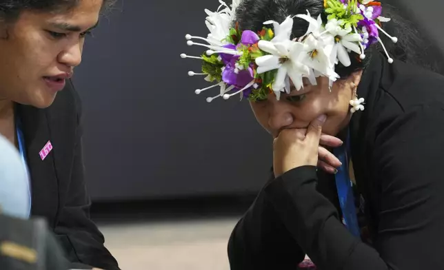 Demi Afasene, of Tuvalu, right, looks through a draft of a proposed deal for curbing climate change at the COP29 U.N. Climate Summit, Friday, Nov. 22, 2024, in Baku, Azerbaijan. (AP Photo/Peter Dejong)