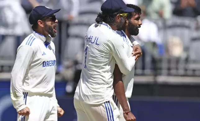 India's Virat Kohli, left, KL Rahul and captain Jasprit Bumrah celebrate the wicket of Australia's Travis Head on the fourth day of the first cricket test between Australia and India in Perth, Australia, Monday, Nov. 25, 2024. (AP Photo/Trevor Collens)