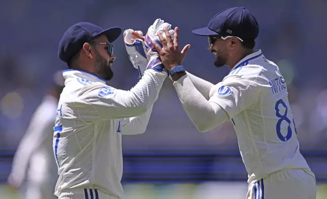 India's Rishabh Pant, left, celebrates with teammate Nitish Kumar Reddy the wicket of Australia's Usman Khawaja on the fourth day of the first cricket test between Australia and India in Perth, Australia, Monday, Nov. 25, 2024. (AP Photo/Trevor Collens)