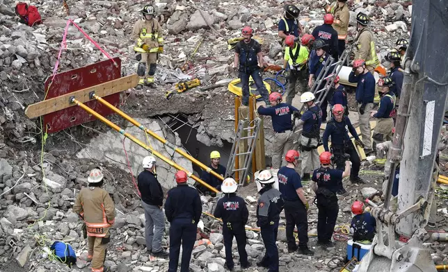 Members of the Louisville Metro Fire Department work to rescue a worker trapped under rubble at construction site in Louisville, Ky., Thursday, Nov. 14, 2024. (AP Photo/Timothy D. Easley)