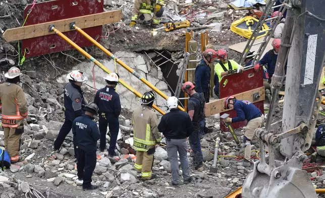 Members of the Louisville Metro Fire Department work to rescue a worker trapped under rubble at a construction site in Louisville, Ky., Thursday, Nov. 14, 2024. (AP Photo/Timothy D. Easley)