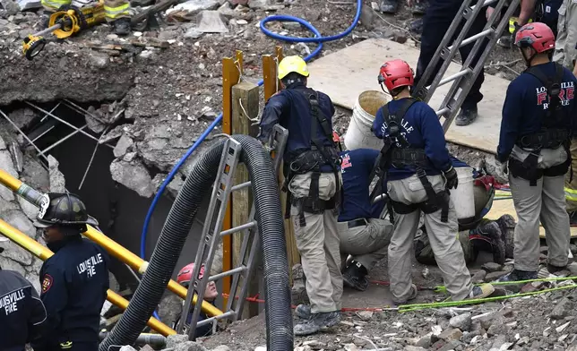 Members of the Louisville Metro Fire Department work to rescue a worker trapped under rubble at construction site in Louisville, Ky., Thursday, Nov. 14, 2024. (AP Photo/Timothy D. Easley)