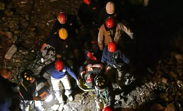 Members of the Louisville Metro Fire Department carry an injured worker to safety after being trapped under rubble at construction site in Louisville, Ky., Thursday, Nov. 14, 2024. (AP Photo/Timothy D. Easley)