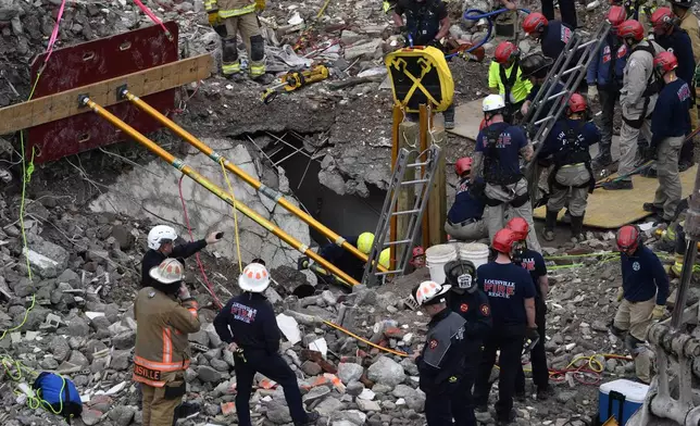 Members of the Louisville Metro Fire Department work to rescue a worker trapped under rubble at construction site in Louisville, Ky., Thursday, Nov. 14, 2024. (AP Photo/Timothy D. Easley)