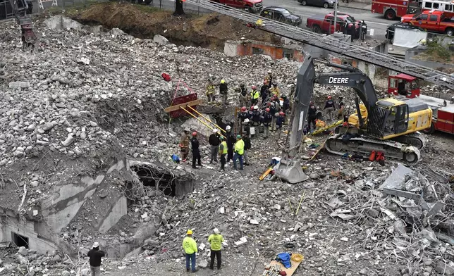 Members of the Louisville Metro Fire Department work to rescue a worker trapped under rubble at construction site in Louisville, Ky., Thursday, Nov. 14, 2024. (AP Photo/Timothy D. Easley)