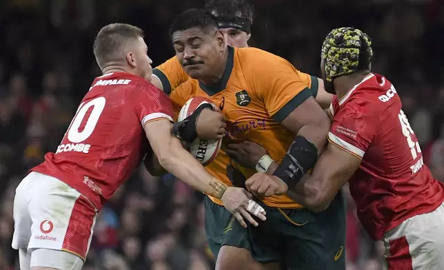 Australia's Will Skelton, center , is blocked by Wales' Christ Tshiunza, right and Wales' Gareth Anscombe during the Autumn Nations series rugby union match between Wales and Australia at the Principality Stadium in Cardiff, Wales, Sunday, Nov. 17, 2024.(AP Photo/Rui Vieira)