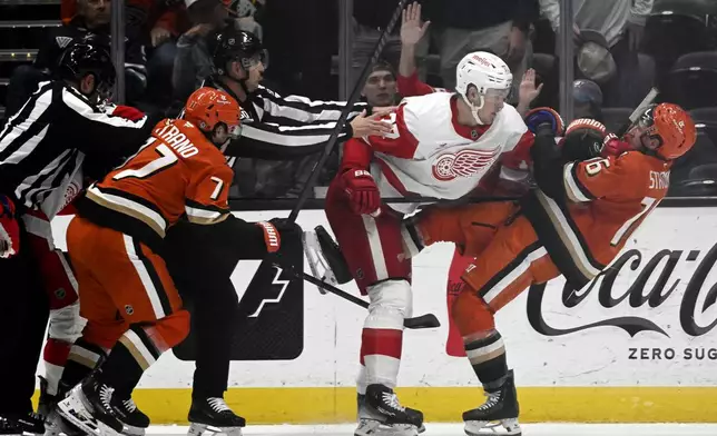 Anaheim Ducks center Ryan Strome, right, gets punched back by Detroit Red Wings defenseman Simon Edvinsson, second from right, with right wing Frank Vatrano, left, watching during the second period of an NHL hockey game in Anaheim, Calif., Friday, Nov. 15, 2024. (AP Photo/Alex Gallardo)