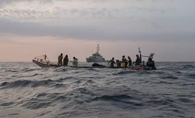 Senegalese sailors in their zodiac, background, approach a fishermen's pirogue to check during a mission to search for migrant boats near the coast of Dakar, Senegal, Saturday, Nov.16, 2024. (AP Photo/Sylvain Cherkaoui)