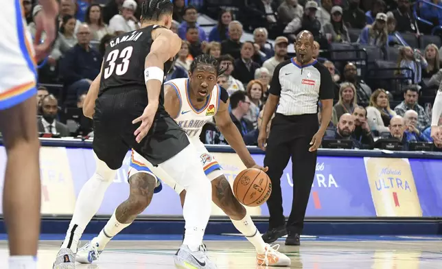 Oklahoma CIty Thunder forward Jalen Williams, right, looks for an opening past Portland Trail Blazers forward Toumani Camara, left, during the second half of an NBA basketball game, Wednesday, Nov. 20, 2024, in Oklahoma City. (AP Photo/Kyle Phillips)