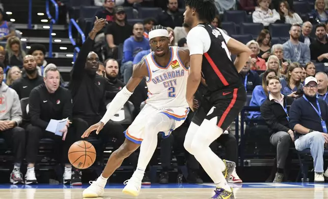 Oklahoma CIty Thunder guard Shai Gilgeous-Alexander, left, drives past Portand Trail Blazers guard Shaedon Sharpe, right, during the second half of an NBA basketball game, Wednesday, Nov. 20, 2024, in Oklahoma City. (AP Photo/Kyle Phillips)