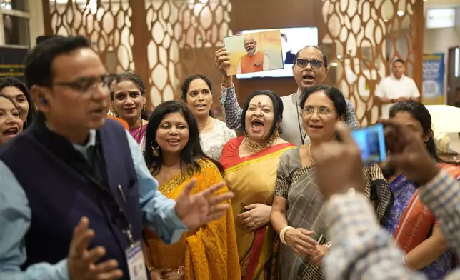 Members of Guyana's Hindu community wait for India's Prime Minister Narendra Modi to arrive to his hotel from the airport in Georgetown, Guyana, Tuesday, Nov. 19, 2024. (AP Photo/Matias Delacroix)