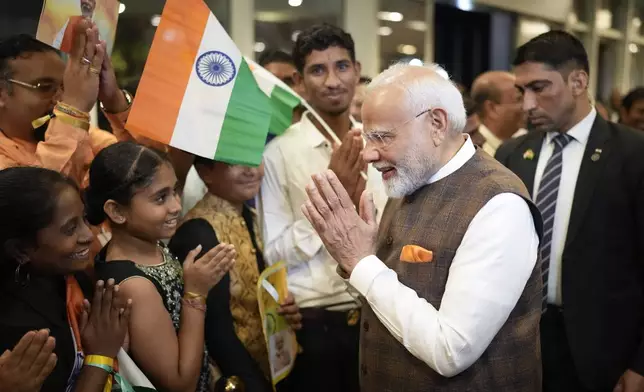 India's Prime Minister Narendra Modi gestures to members of Guyana's Hindu community as he arrives from the airport to his hotel in Georgetown, Guyana, Tuesday, Nov. 19, 2024. (AP Photo/Matias Delacroix)