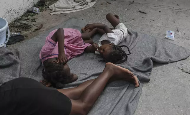 Children sleep on the floor at a school where residents of the Nazon neighborhood displaced by gang violence have sought refuge, in Port-au-Prince, Haiti, Thursday, Nov. 14, 2024. (AP Photo/Odelyn Joseph)