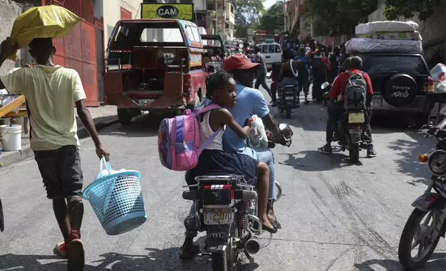 Residents flee their homes to escape gang violence in the Nazon neighborhood of Port-au-Prince, Haiti, Thursday, Nov. 14, 2024. (AP Photo/Odelyn Joseph)