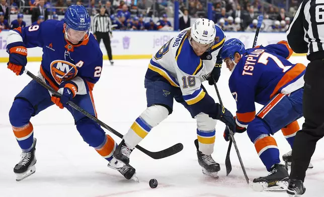 St. Louis Blues center Robert Thomas (18) battle New York Islanders center Brock Nelson (29) and right wing Maxim Tsyplakov (7) for the puck during the second period of an NHL hockey game, Saturday, Nov. 23, 2024, in New York. (AP Photo/Noah K. Murray)